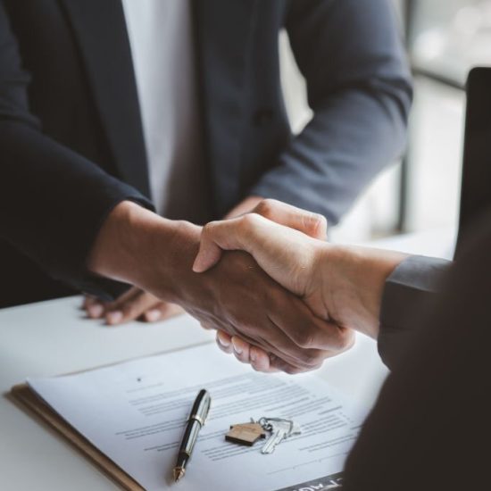 The salesperson of the housing estate in the project and the customer shake hands after successfully signing the contract. Concept of selling housing estates and real estate.